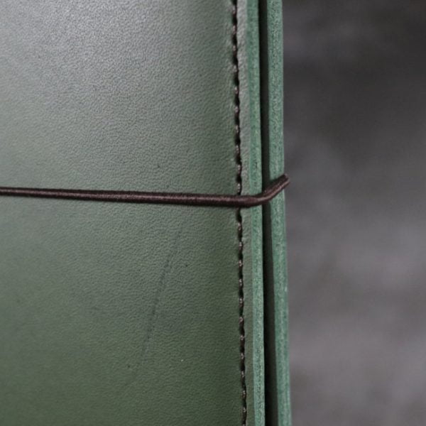 leather notebook cover elastic forest closeup